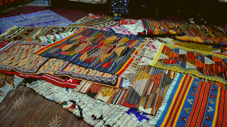 An array of colorful rugs placed out on the ground