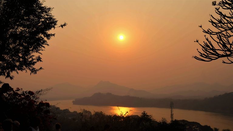 Sunsets behind the mountains as it reflect on the Mekong River