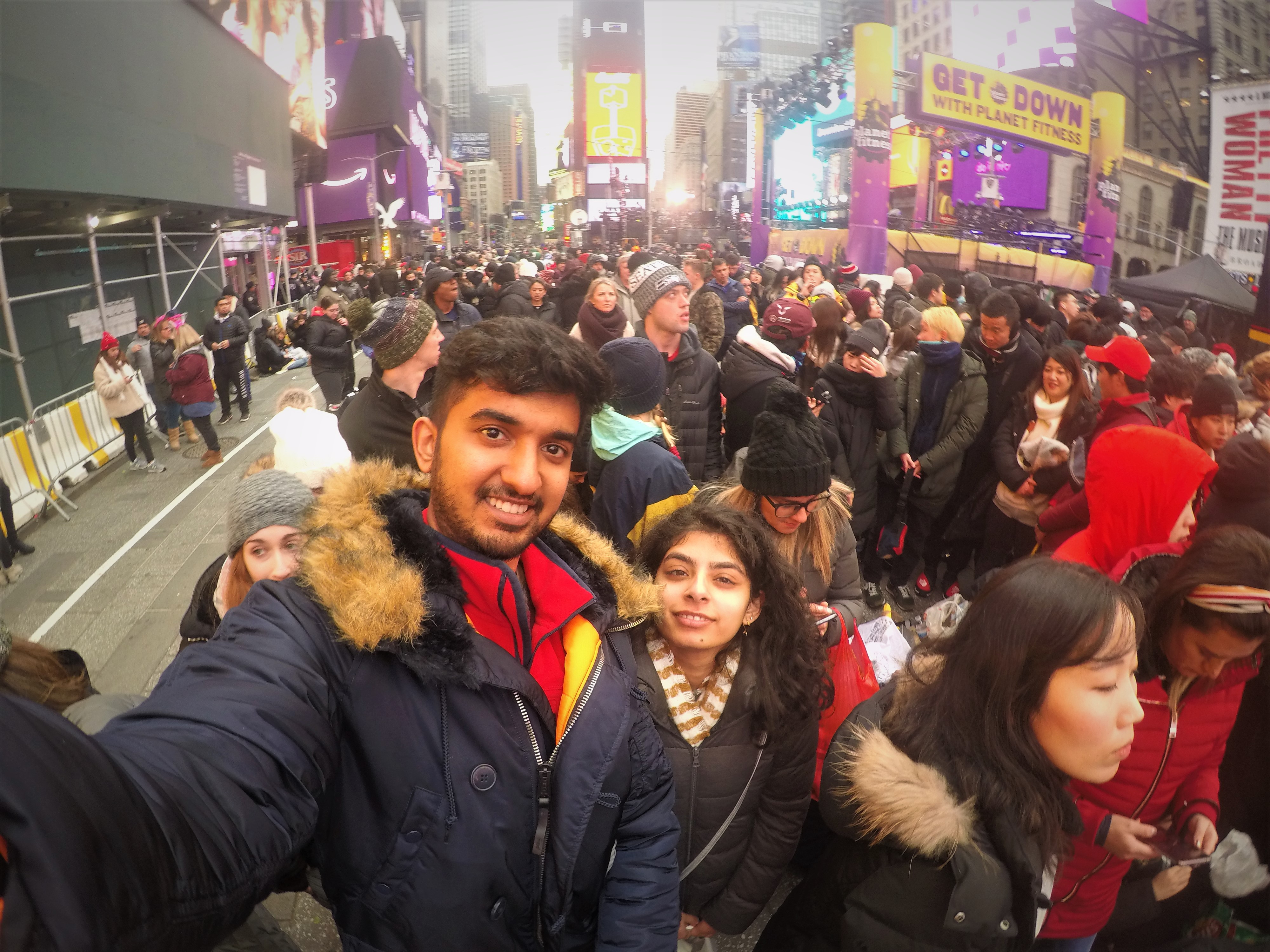 Anmol and Nishil take a selfie in front of New Years Eve Crowd