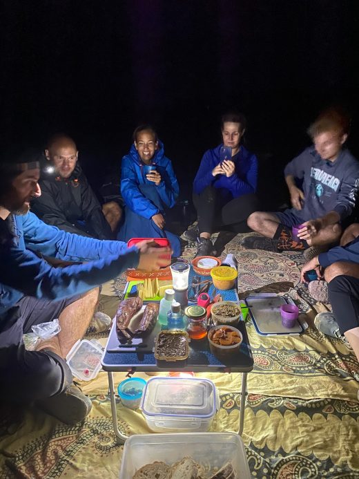 Group Eating dinner at night in camping style